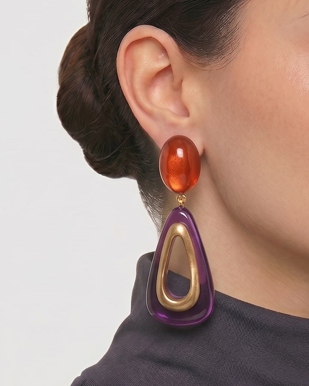 modelo luciendo el pendiente Fleur de Prune en la oreja, apreciando su silueta estilizada y escala sobre la piel.
