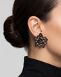 modelo luciendo los pendientes Fleur de Lotus Noir et Bronze en las orejas, apreciando su forma floral tridimensional y ajuste elegante al lóbulo.