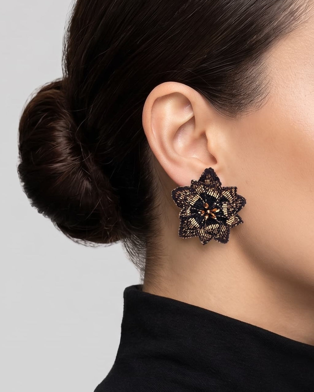 modelo luciendo los pendientes Fleur de Lotus Noir et Bronze en las orejas, apreciando su forma floral tridimensional y ajuste elegante al lóbulo.