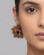 modelo luciendo los pendientes Fleur de Lotus Bronze en las orejas, apreciando su forma floral tridimensional y ajuste al lóbulo.