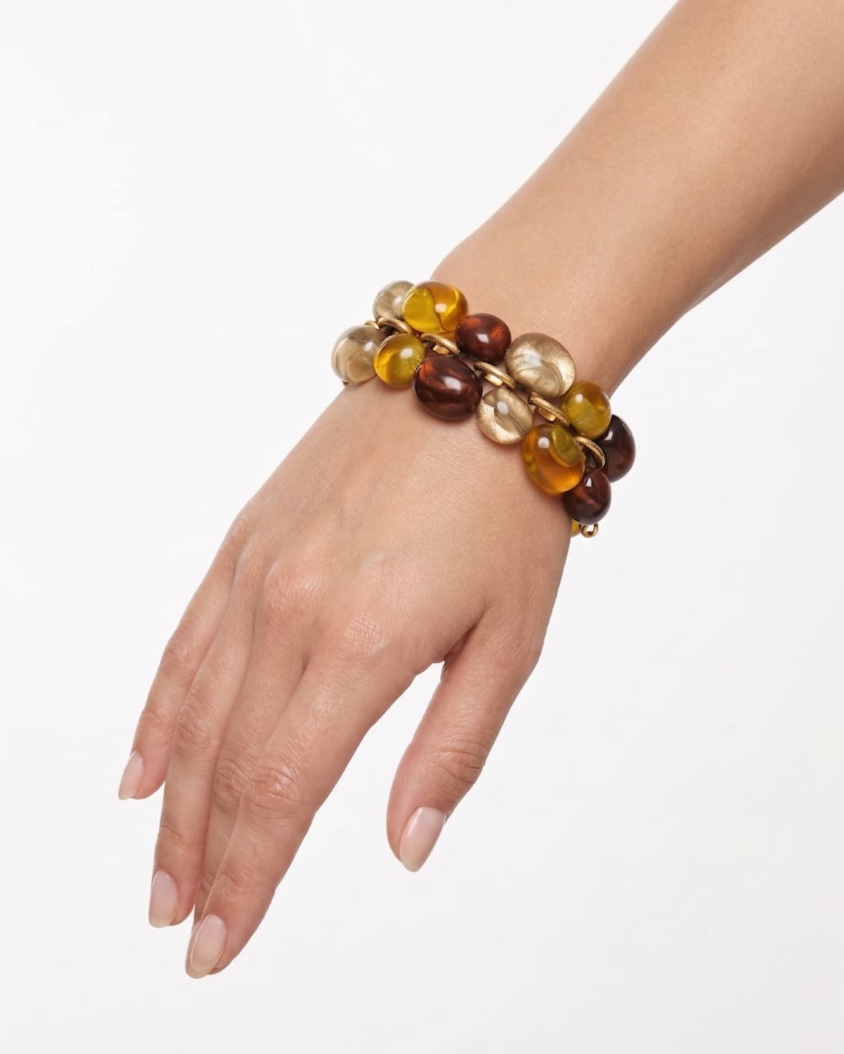 modelo luciendo la pulsera Galet Ambre en la muñeca, apreciando su volumen, brillo y textura sobre la piel.