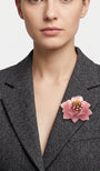 modelo de frente portando el broche maxi de loto rosa prendido en la solapa de una blazer de sastre gris marengo, mostrando su escala elegante.