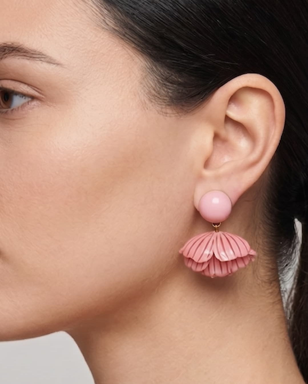 vista de perfil del pendiente rosa de Ciléa Paris colocado en una modelo, detallando su volumen tridimensional y su escala elegante.