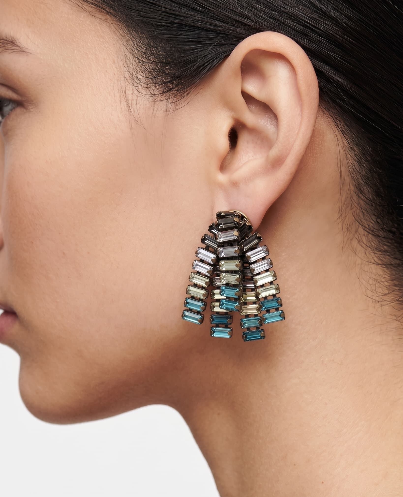 Mujer luciendo los pendientes "Marea de Cristal", destacando el brillo de las cuentas azules y su diseño vertical.