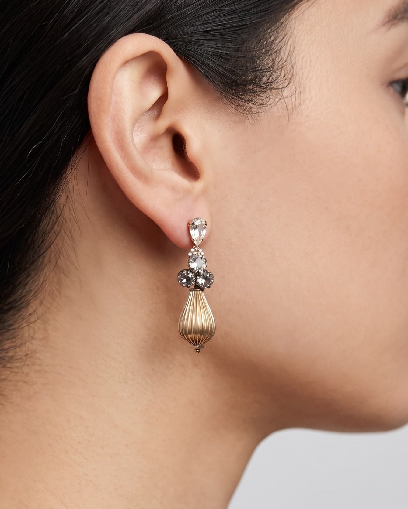 Mujer luciendo los pendientes "Gota de Palacio", destacando su diseño vertical y brillo clásico.