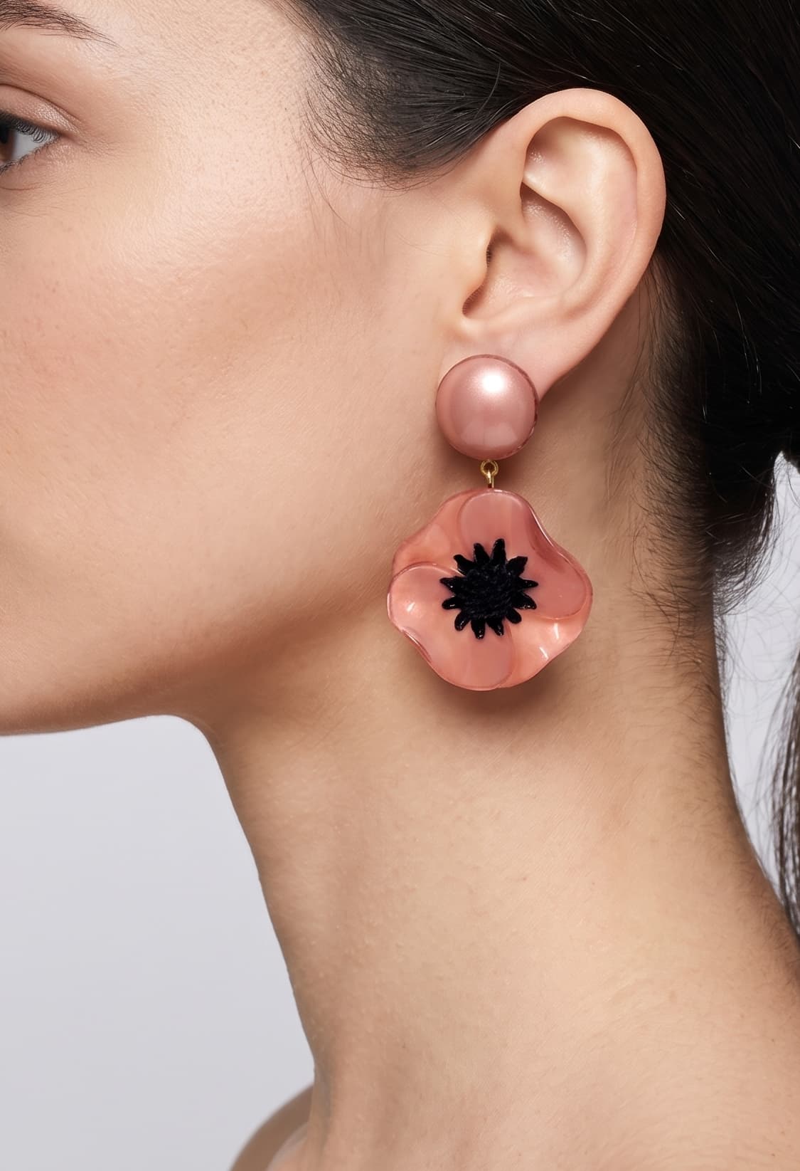 vista de perfil del pendiente de amapola rosa de Ciléa Paris colocado en una modelo, detallando el ajuste de su cierre de pinza y su escala maxi.