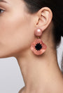 vista de perfil del pendiente de amapola rosa de Ciléa Paris colocado en una modelo, detallando su volumen floral y su escala elegante.