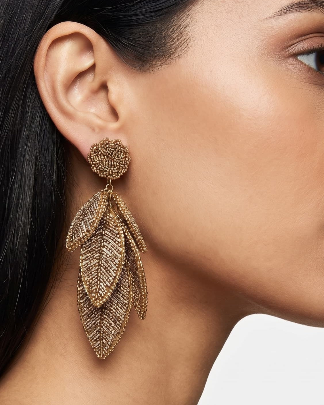 Primer plano lateral de mujer luciendo los pendientes "Bruma de Oro", resaltando su caída elegante y su brillo cálido.