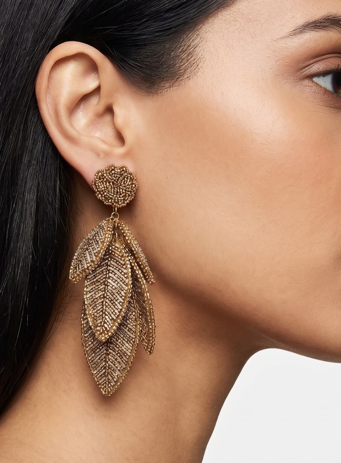 Primer plano lateral de mujer luciendo los pendientes "Bruma de Oro", resaltando su caída elegante y su brillo cálido.
