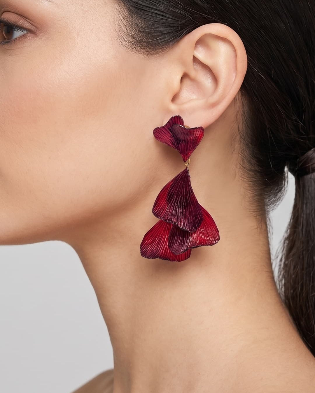 vista de perfil del pendiente borgoña de Ciléa Paris colocado en una modelo, detallando su elegante caída, escala extra grande y textura.