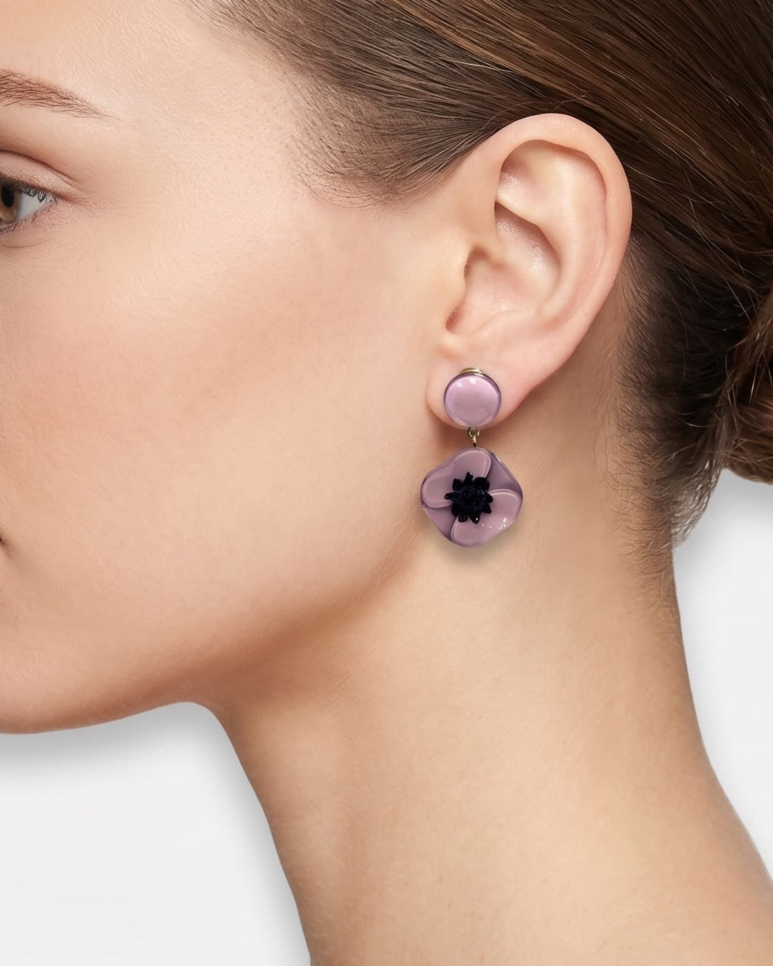 Vista de perfil del pendiente de amapola malva de Ciléa Paris colocado en una modelo, detallando el ajuste de su cierre de pinza y su escala elegante.