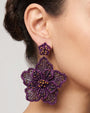modelo luciendo el pendiente Fleur Violette en la oreja, apreciando su escala maxi y volumen floral sobre la piel.