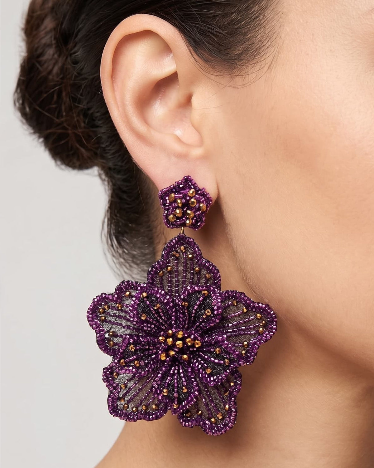 modelo luciendo el pendiente Fleur Violette en la oreja, apreciando su escala maxi y volumen floral sobre la piel.