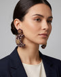 modelo luciendo el pendiente Lune Violette et Dorée en la oreja, apreciando su silueta celestial, destellos metálicos y escala sobre la piel.