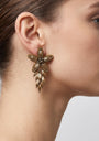 Mujer luciendo los pendientes "Flor de Invierno", destacando su diseño articulado y el acabado en bronce.