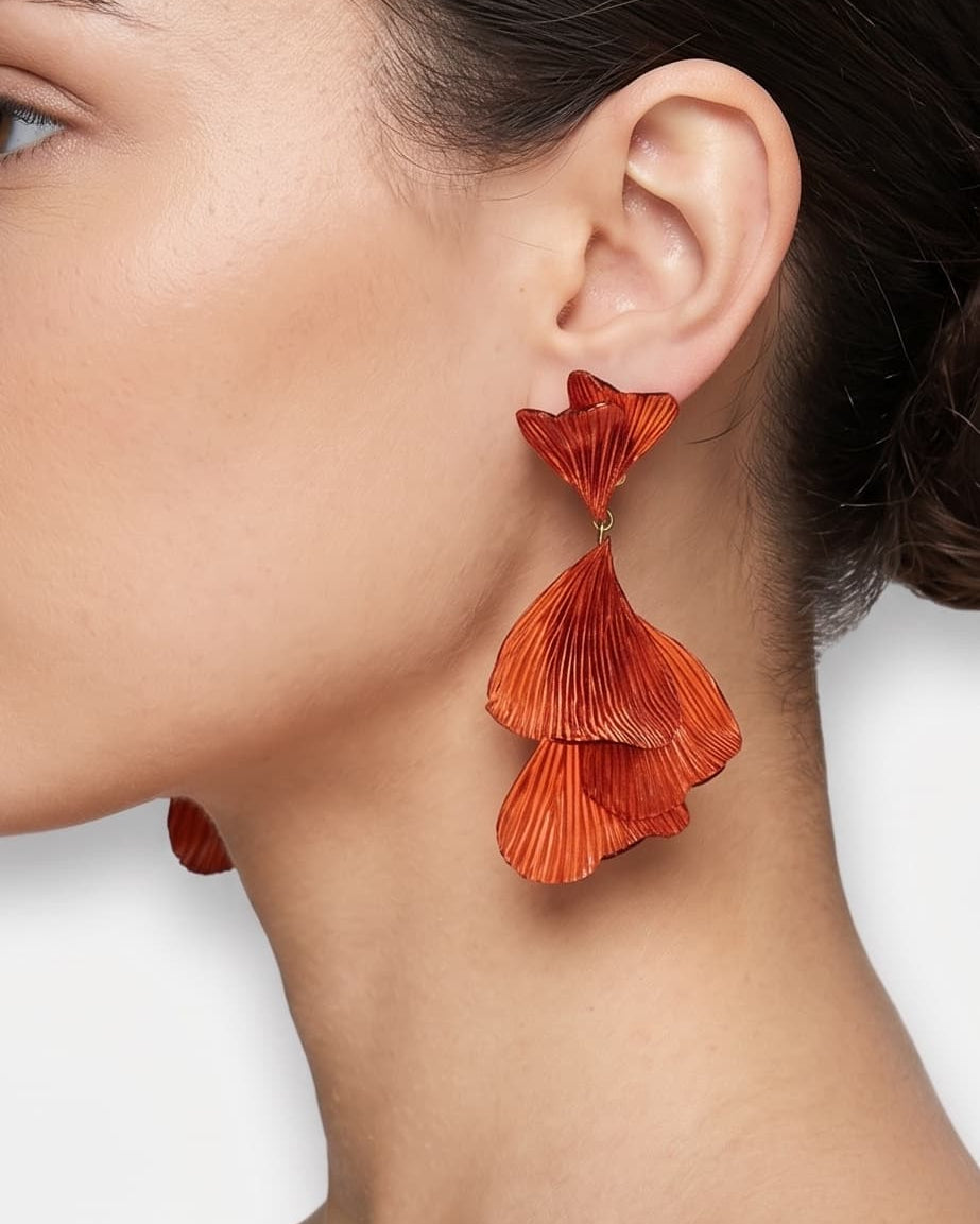 vista de perfil del pendiente de hojas ginkgo color teja de Ciléa Paris colocado en el lóbulo de una modelo, resaltando su caída fluida, su escala maxi de 9x4.5 cm y su sujeción de clip.