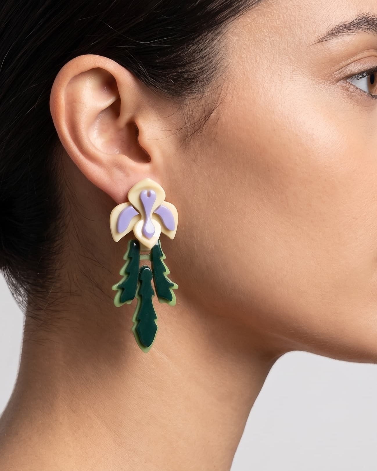 Primer plano lateral de mujer luciendo los pendientes "Iris", resaltando su diseño vertical y su inspiración botánica.