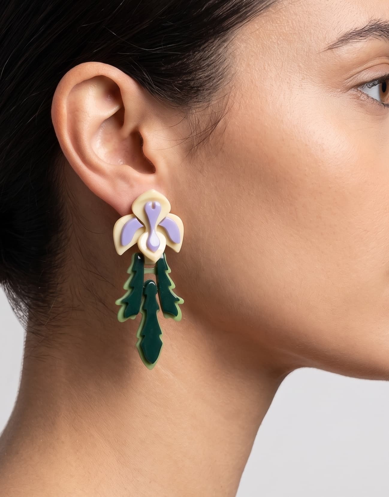 Primer plano lateral de mujer luciendo los pendientes "Iris", resaltando su diseño vertical y su inspiración botánica.