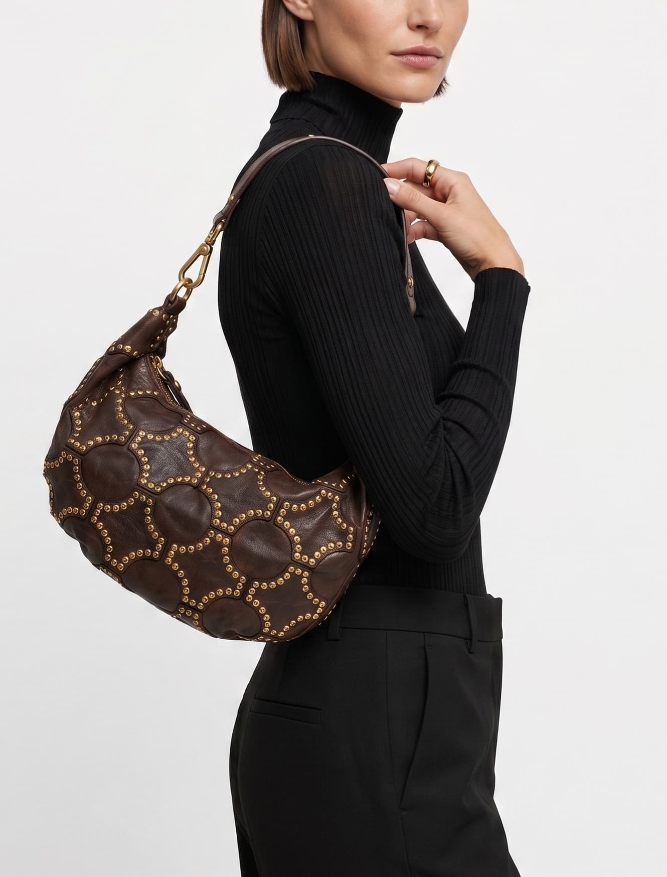 modelo luciendo el bolso Monalisa colgado al hombro, apreciando su silueta curva, su tamaño medio y su estilo bohemio chic.