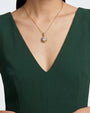 modelo luciendo el Collar Verona de Maria e Luisa sobre un vestido verde, apreciando la caída de la cadena y la escala del medallón.