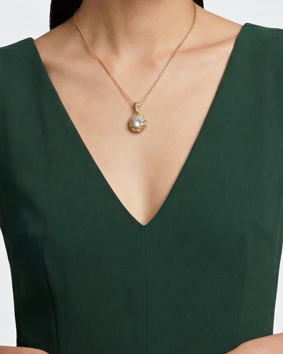 modelo luciendo el Collar Verona de Maria e Luisa sobre un vestido verde, apreciando la caída de la cadena y la escala del medallón.