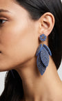 Primer plano lateral de mujer luciendo los pendientes "Bruma de Zafiro", resaltando su caída elegante y su brillo profundo.