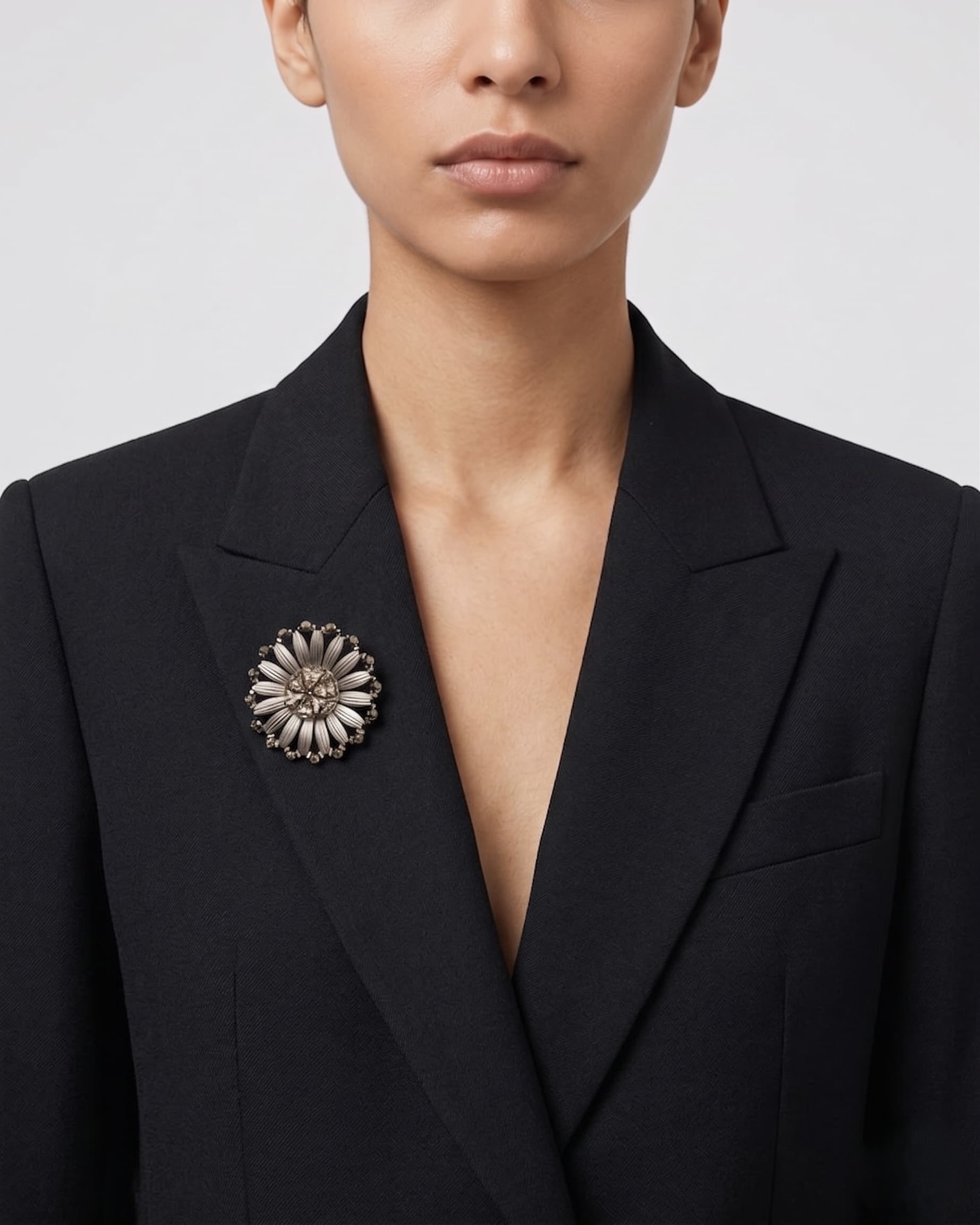Vista de una mujer vistiendo una americana negra con el broche "Margarita Astral" en la solapa, destacando su elegancia.