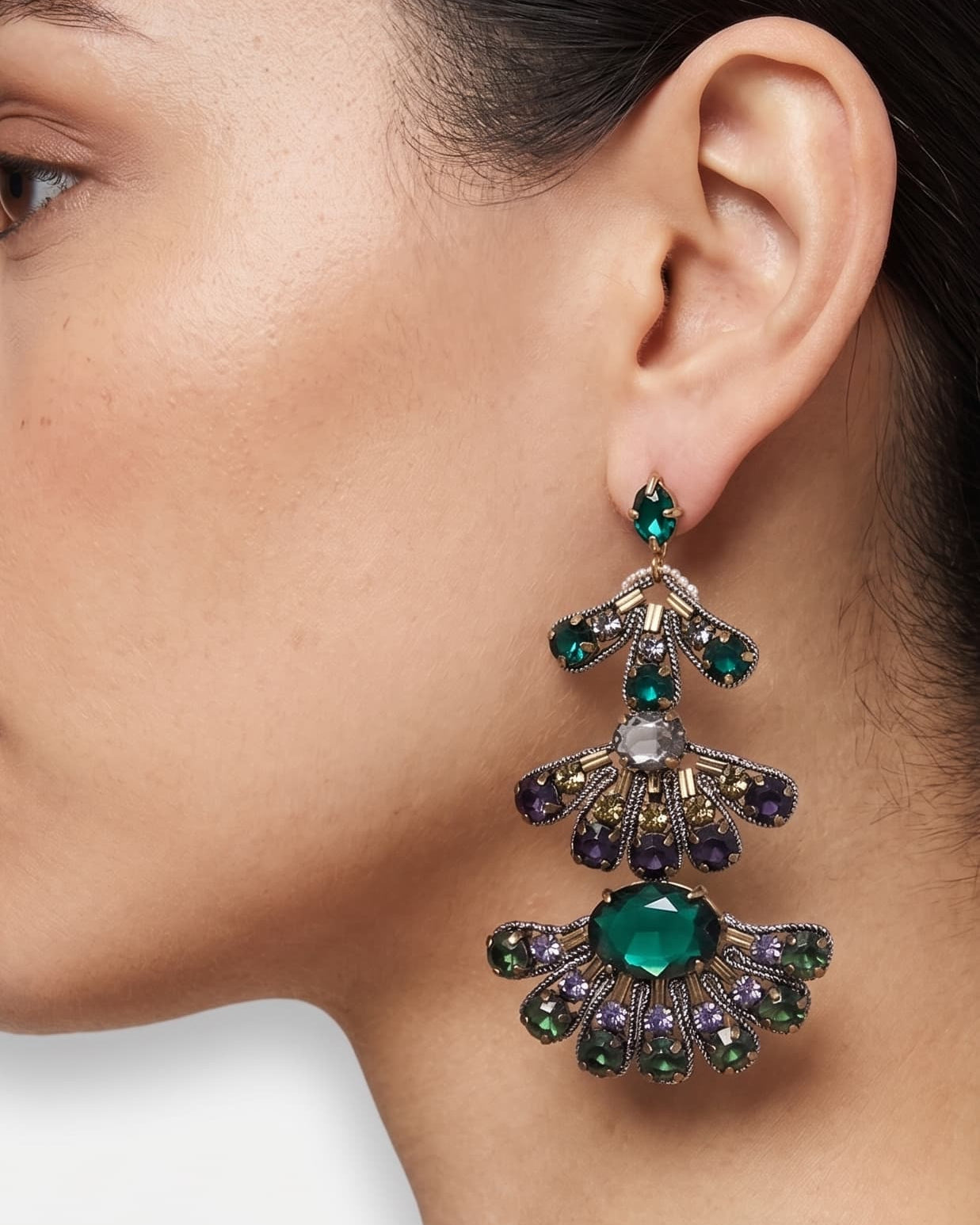 Mujer luciendo los pendientes "Abanico de Esmeralda", destacando su gran formato y el brillo de las piedras facetadas.
