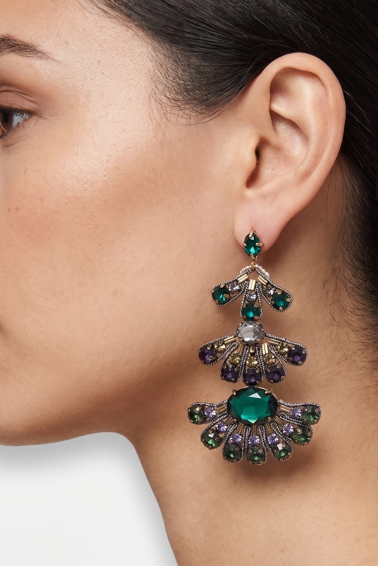 Mujer luciendo los pendientes "Abanico de Esmeralda", destacando su gran formato y el brillo de las piedras facetadas.