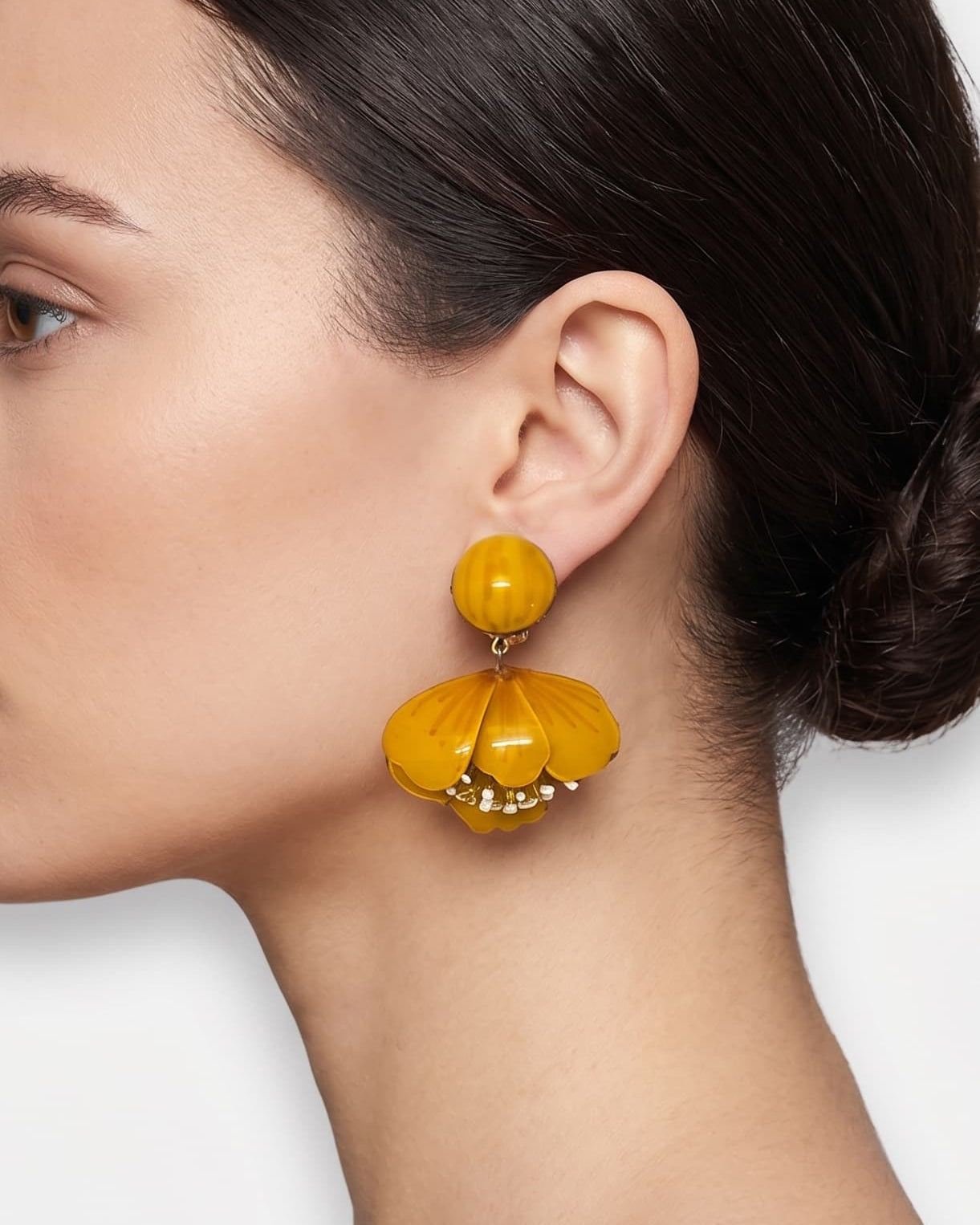 vista de perfil del pendiente de tulipán color miel de Ciléa Paris colocado en el lóbulo de una modelo, detallando su caída, su escala estilizada de 5.5x4.5 cm y su sujeción de perno con tuerca.