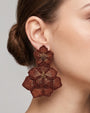 modelo luciendo el pendiente Fleur Double Marron et Bronze en la oreja, apreciando su majestuosa escala XXL sobre la piel.
