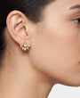 Mujer luciendo los pendientes "Aura Floral", destacando su diseño compacto y la luz del cristal central.