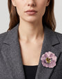 vista frontal del broche de flor de Ciléa Paris colocado en la solapa de una chaqueta de sastre gris, detallando su escala maxi y su elegancia romántica.