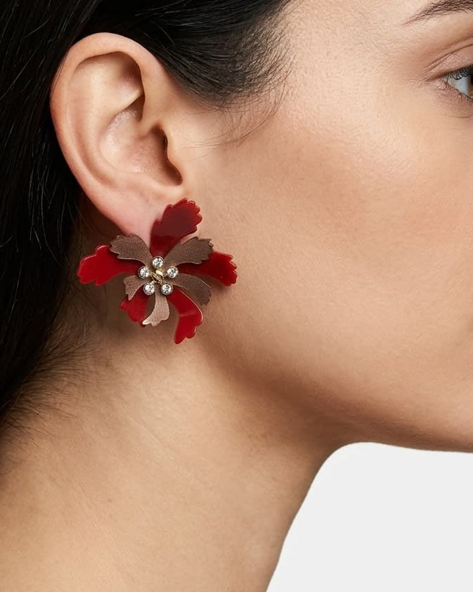 Primer plano lateral de mujer luciendo los pendientes "Flor de Fuego", resaltando su color vibrante y diseño floral.
