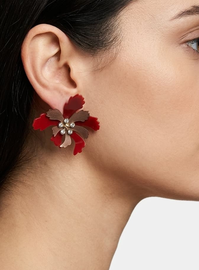 Primer plano lateral de mujer luciendo los pendientes "Flor de Fuego", resaltando su color vibrante y diseño floral.