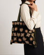 modelo llevando al hombro el bolso Cabas en Velours Motifs Astraux de Olivia Dar, apreciando su proporción y riqueza textil sobre la ropa.
