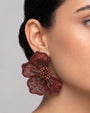 modelo luciendo el pendiente Fleur Rouge et Bronze en la oreja, apreciando su silueta en abanico y calidez cromática sobre la piel.