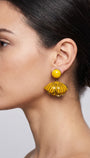 vista de perfil del pendiente amarillo de Ciléa Paris colocado en una modelo, detallando el ajuste de su cierre de pinza y su elegante escala tridimensional.