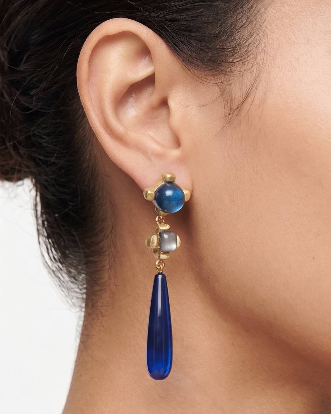 modelo luciendo el pendiente Inès Bleu Caída en la oreja, apreciando su caída estilizada y tono cobalto sobre la piel.