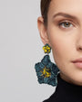 modelo luciendo el pendiente Fleur Vert et Jaune en la oreja, apreciando su silueta maxi y contraste cromático sobre la piel.