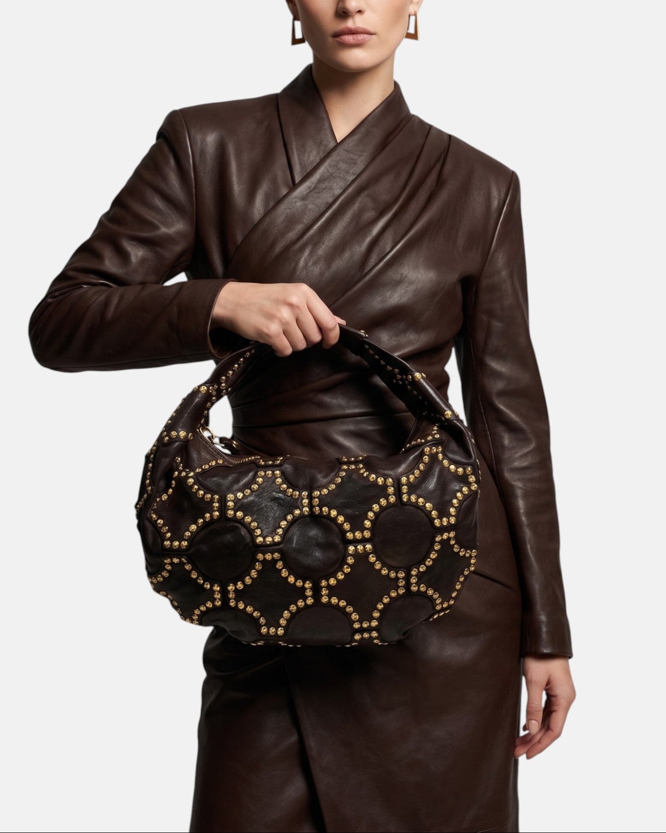 modelo luciendo el bolso Ginebra en la mano, apreciando su silueta curva, su gran escala y su estilo bohemio chic.