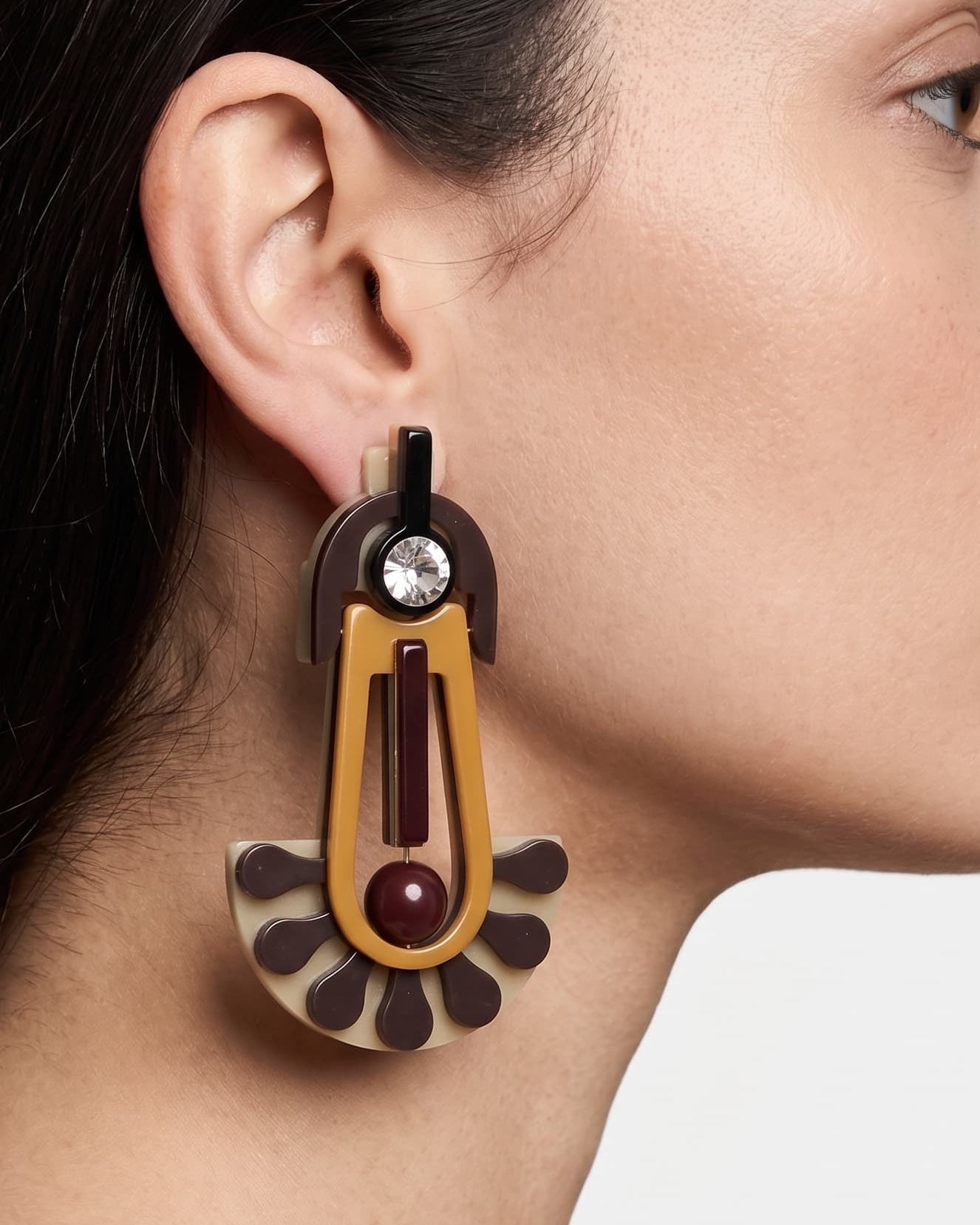 Primer plano lateral de mujer luciendo los pendientes "Amuleto Solar", resaltando su diseño de inspiración tribal y elegancia contemporánea.