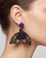 modelo luciendo el pendiente Papillon de Nuit en la oreja, apreciando su silueta de alas desplegadas y volumen sobre la piel.