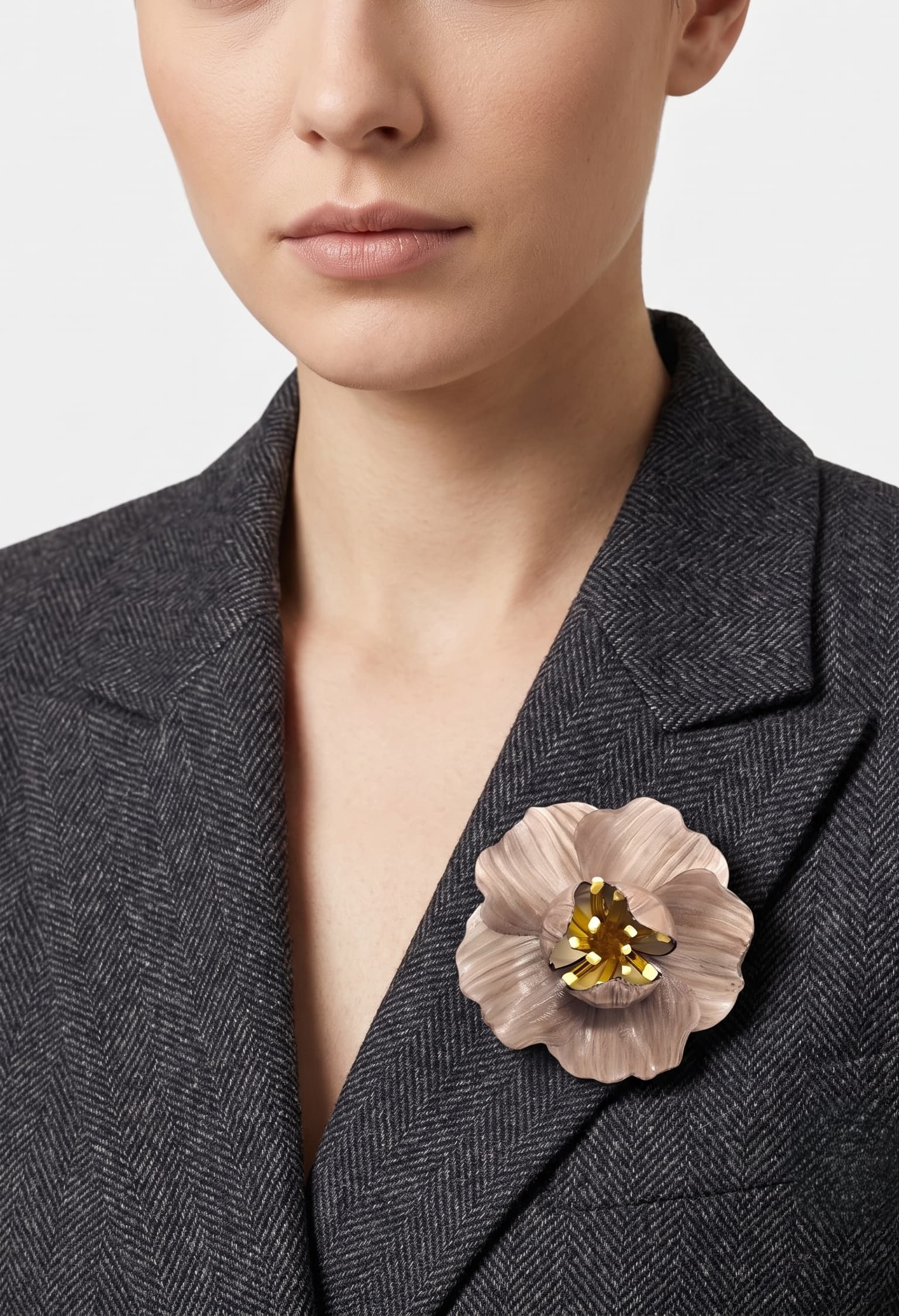 vista frontal del broche de flor de Ciléa Paris colocado en la solapa de una chaqueta de sastre gris, detallando su escala maxi y su elegancia.