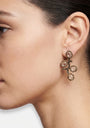Mujer luciendo los pendientes "Brote de Invierno", destacando su diseño orgánico y brillo cristalino.