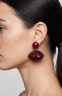 perfil del pendiente borgoña de Ciléa Paris colocado en una modelo, detallando su volumen tridimensional y su escala elegante.