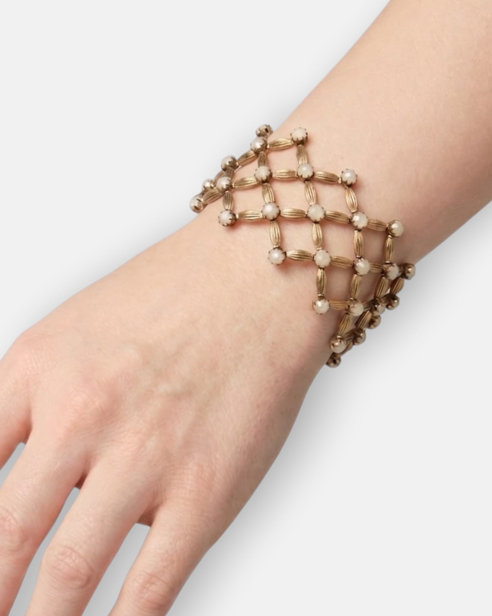 Vista del brazalete de rejilla "Red de Luces Ópalo" en la muñeca, mostrando su transparencia calada y formato ancho.