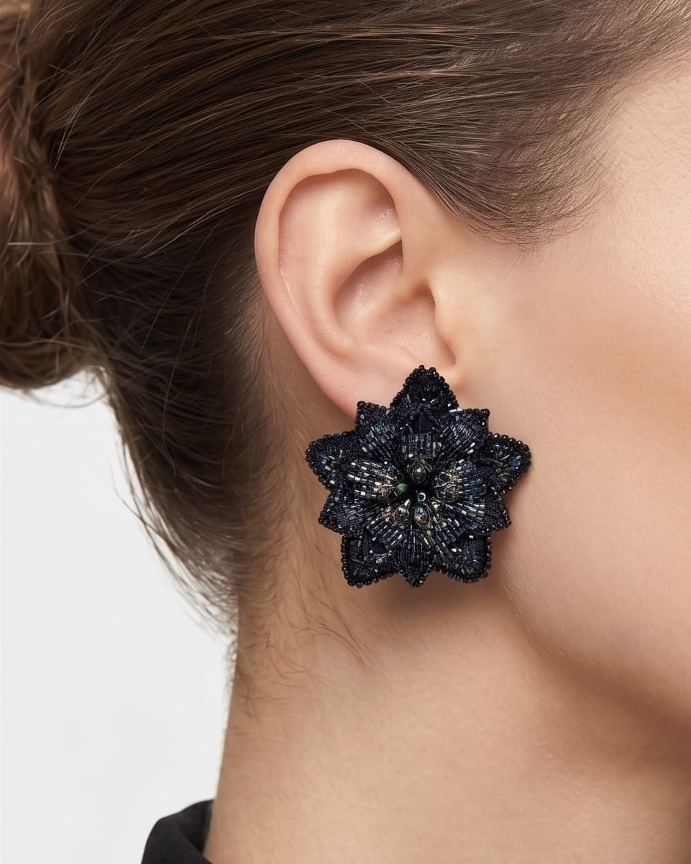 modelo luciendo los pendientes Fleur de Lotus Bleu Nuit en las orejas, apreciando su forma floral tridimensional y ajuste elegante al lóbulo.