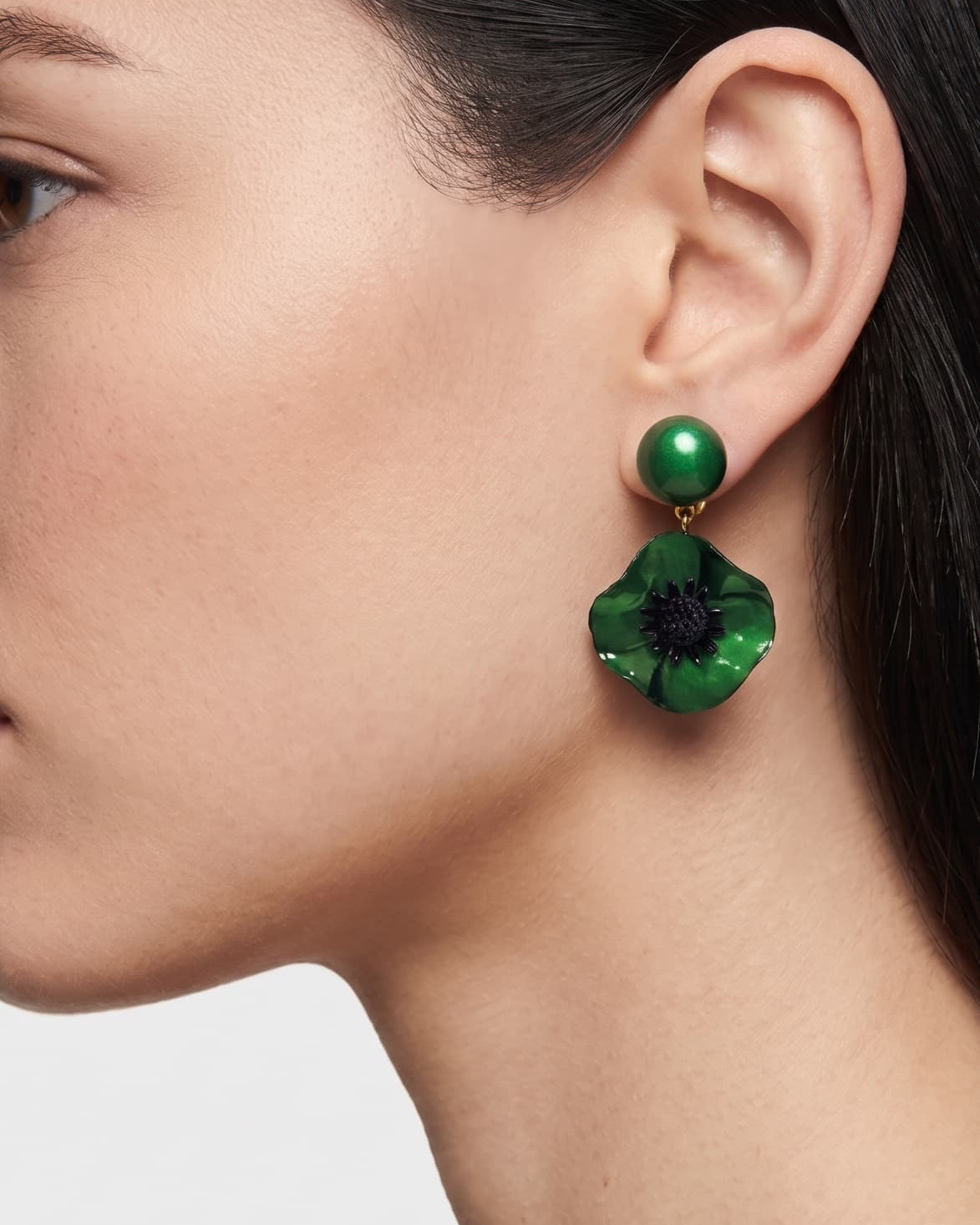 vista de perfil del pendiente de amapola verde de Ciléa Paris colocado en una modelo, detallando su volumen floral y su escala elegante.