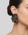 modelo luciendo el pendiente Fleur Noire et Bronze en la oreja, apreciando su silueta en abanico y escala sobre la piel.